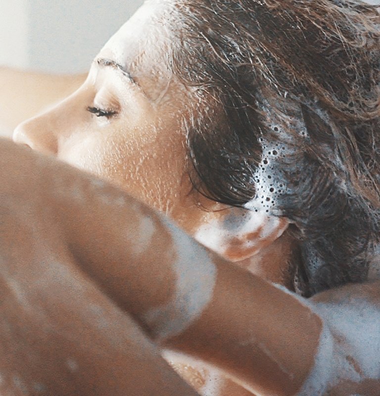 Frau wäscht ihre Haare